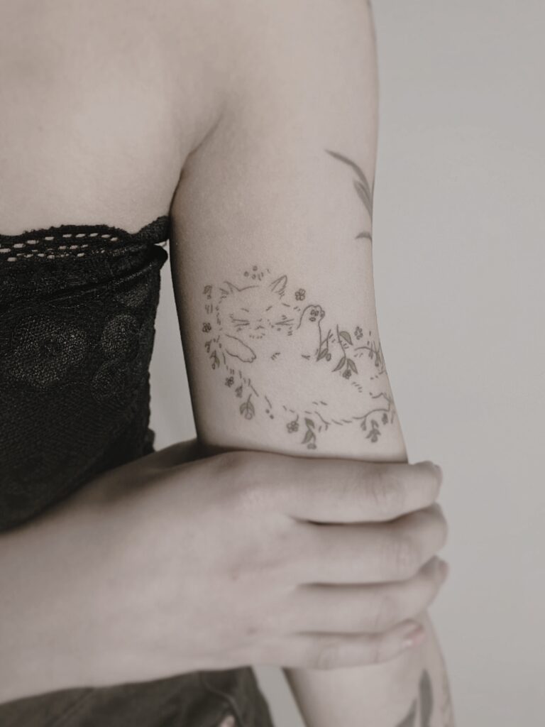 Tattoo-Helsinki-linework-cat-on-the-grass-happy-floral-scaled.jpg